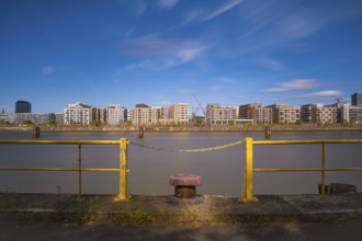 View over a harbour basin to a part of the Hamburg Hafencity in the foreground a yellow railing
