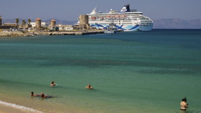Large cruise ship in the harbour near a beach with turquoise water and bathers, Sachtouri Beach,