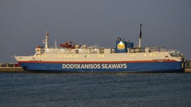 A Dodekanisos Seaways ferry docks at dusk in the harbour by the calm sea, Rhodes Old Town, Rhodes