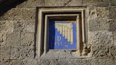 Kasteliani Public Library, Italian coat of arms, Historical façade with a decorative relief and the