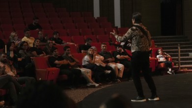 Audience members dance and clap as Turkish singer Coskun Sabah performs during the Türkiye Kültür