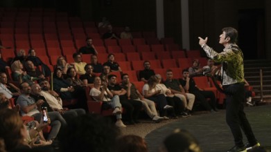 Audience members dance and clap as Turkish singer Coskun Sabah performs during the Türkiye Kültür
