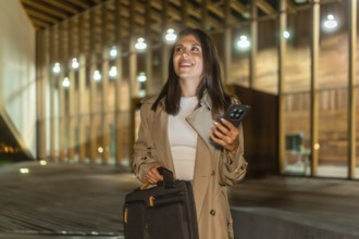 Young businesswoman walking confidently at night in an urban setting, carrying a briefcase and