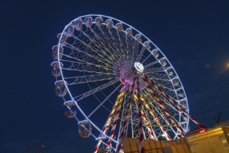 Ferris wheel illuminating the night sky during christmas festivities in bayonne, france, creating a