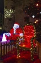 Luminous santa claus installation sitting on his throne during christmas festivities in bayonne,