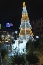 Luminous christmas tree and reindeer decorations create a festive atmosphere in bayonne, france,