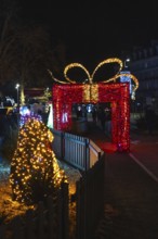 Christmas lights illuminating a giant gift shaped arch during the festive season in bayonne,