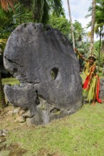 Local boy in traditional traditional costume from Yap Island as size comparison next to oversized