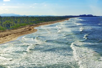 Aerial view of strong surf rolling in with whitecaps at coastal cut-off near Punta Cana, Dominican