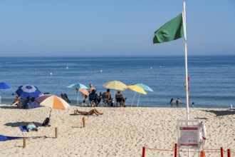 Kilometre-long sandy beach Praia do Barril, on the island off Santa Luzia, green flag indicates