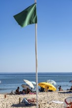 Kilometre-long sandy beach Praia do Barril, on the island off Santa Luzia, green flag indicates
