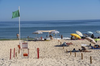 Kilometre-long sandy beach Praia do Barril, on the island off Santa Luzia, green flag indicates