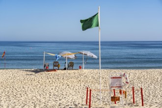 Kilometre-long sandy beach Praia do Barril, on the island off Santa Luzia, green flag indicates