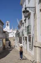 Faro, old town centre alley, R. do Municipio, view of the Arco da Vila city gate, Algarve, Portugal