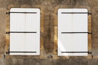 2 white, closed wooden windows, historic house façade, yellow sandstone, Marville, Renaissance