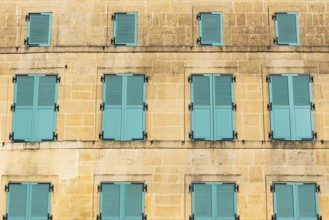 Closed, green shutters, historic house façade, yellow sandstone, Marville, Renaissance village,