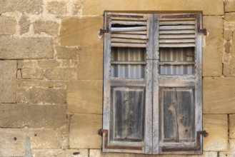 Closed wooden window, historic house facade, yellow sandstone, Marville, Renaissance village,