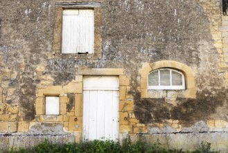 Closed white wooden door and windows, historic house façade, yellow sandstone, Marville,