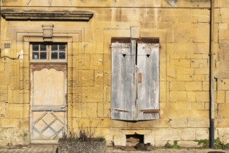 Closed wooden door and windows, historic house façade, yellow sandstone, Marville, Renaissance