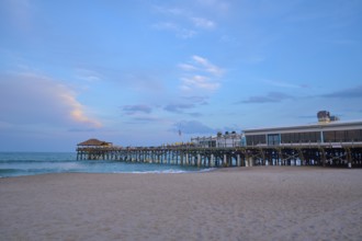 A quiet beach with a long wooden pier under a blue evening sky, Westgate Cocoa Beach Pier, Cocoa