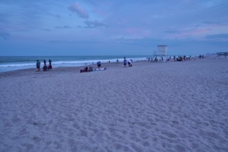 People enjoying the beach at dusk under a blue sky, Cocoa Beach, Port Canaveral, Florida, USA