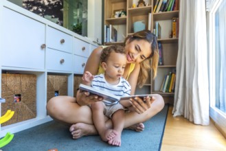 Smiling mother and baby son sharing joyful moments while reading books together, fostering a love