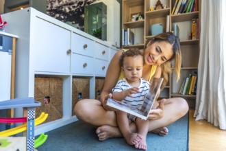 Happy mother and baby son sharing a joyful moment while reading a book together, creating lasting
