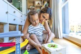 Mom and her son are sitting on the floor enjoying playtime with colorful educational toys,