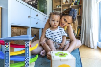 Happy mother and son playing with educational toys, enjoying quality time together in a cozy home