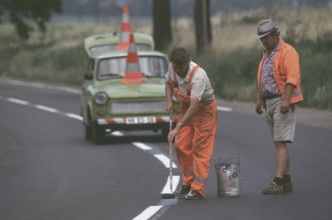 DEU, Erfurt, 01.07.1990 -- Road marking work with duty trombi outside Erfurt. -- Road workers on a