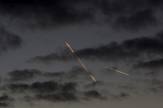 Contrails from passenger aircraft in the evening sky over Berlin