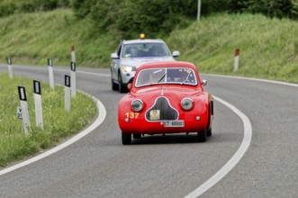 A red classic car is accompanied by a police car on a country road, classic car, car race, Mille