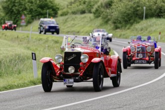 Red classic car in a convoy on a winding country road, classic car, car race, Mille Miglia, 1000