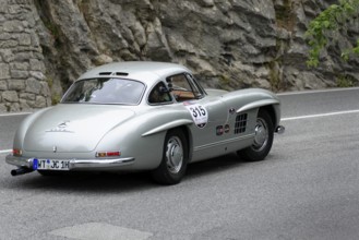 No.315, Merdedes-Benz 300SL W 198, year 1954, Silver classic car driving on a road with rocks in
