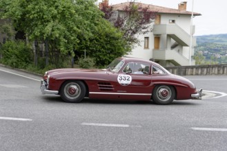 No. 332, Mercedes-Benz 300 SL W 198, model year 1955, Red classic car in a bend in front of a house