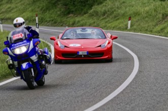 Blue motorbike overtakes red Ferrari convertible on winding road, classic car, car race, Mille