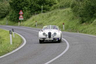 Classic car in white colour drives on winding country road, classic car, car race, Mille Miglia,