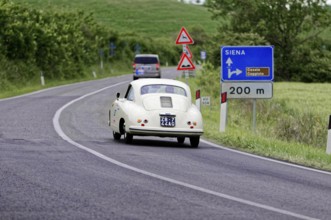 White retro limousine with traffic signs and green landscape, classic car, car race, Mille Miglia,
