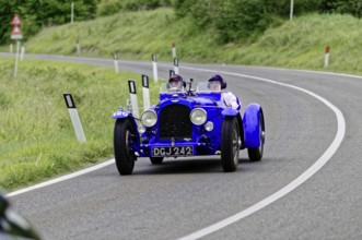 Blue vintage racing car with two people on a country road, classic car, car race, Mille Miglia,
