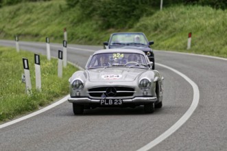 Silver classic car on a winding, rural road accompanied by a blue car, classic car, car race, Mille