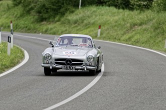 A silver Mercedes classic car drives through a bend, classic car, car race, Mille Miglia, 1000