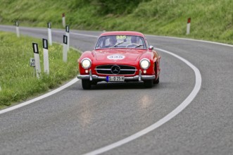 A classic red Mercedes vintage car on a winding country road, classic car, car racing, Mille