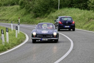 A black Mercedes vintage car drives a small car on a country road, vintage car, car race, Mille