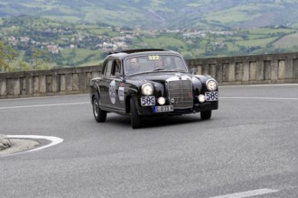 No. 322, Mercedes-Benz 220A, model year 1955, black vintage car driving on a winding road through a