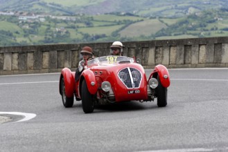 No.197, Healey 2400 Silverstone, built in 1950, red car with two occupants in classic helmets on a