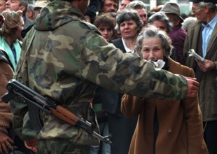 BIH, Bosnia, Sarajevo, 16.09.1992, woman is held back by a bus evacuating people from Sarajevo