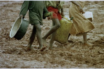 RWA, Benaco camp, 19.05.1994 -- Refugee children wander through the muddy paths of the Benaco camp