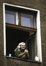 Berlin, DEU, 18.10.1999 -- A woman wearing a beauty mask (yogurt on face, face cream) looks out a