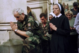 BIH, Sarajevo, 01.09.1995 -- A Bosnian soldier prays together with a Catholic nun during a service