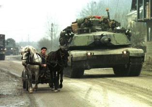BIH, Tuzla, 01.01.1996 -- An American Abraham tank overtakes a Bosnian carriage near Tuzla. --